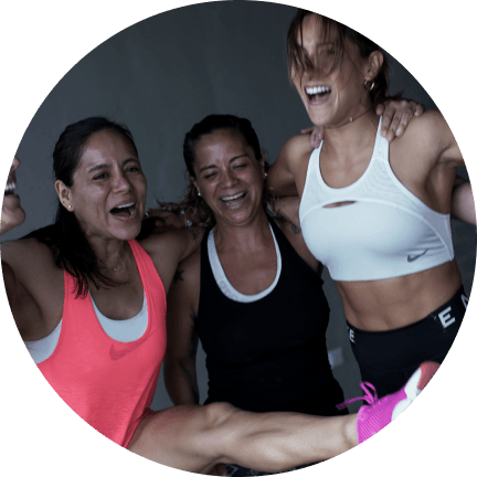 Mujeres sonrientes se abrazan en ropa de deporte.